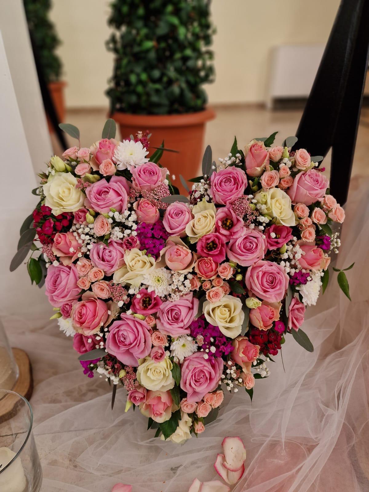 Herzförmiges Blumengesteck aus rosafarbenen und cremefarbenen Rosen